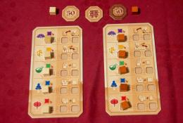 Herní destičky obou hráčů včetně žetonů 50+ bodů a žeton začínajícího hráče