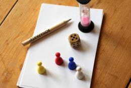 Herní komponenty (papíry na zapisování tipů, kostka, figurky, tužka a přesýpací hodiny)