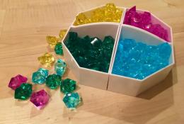 Krystaly, se kterými se ve hře obchoduje (nejméně hodnotné žluté, zelené, modré a nejlepší růžové)