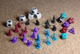 Figurky a kostky hráčů - útočné (d4, d10, d12) a kostky ztrát