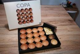 COPA - soubor několika her uložen v krabici. Misky ze dřeva a fazole jako hrací komponenty. 